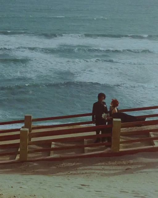 Ceziel y Choco en una baranda de madera frente a las olas